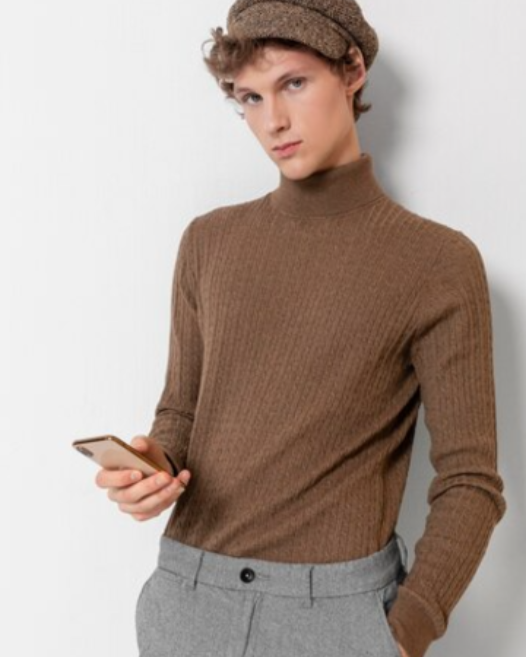 jeune homme debout avec un téléphone dans les mains